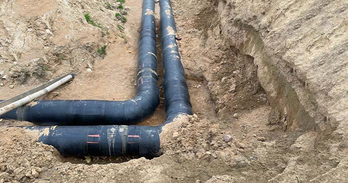 Image: PVC pipes in a trench. When repiping your home, a plumber will replace all the pipes in your plumbing system. 