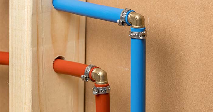 Image: two PEX pipes in a wall, one blue for cold water and one red for warm water. A home repipe takes a few days to a few weeks depending on the size of your home.