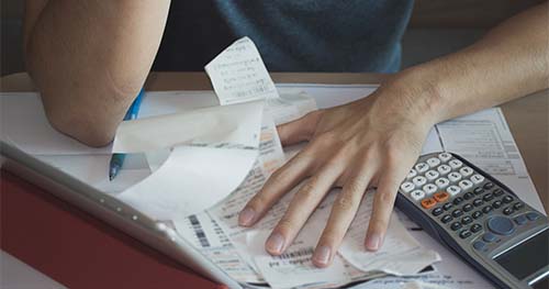 Image: a person going over finances to calculate the cost of a furnace.