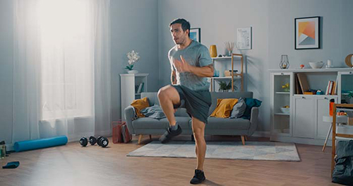 Image: a man works out in his well ventilated home.