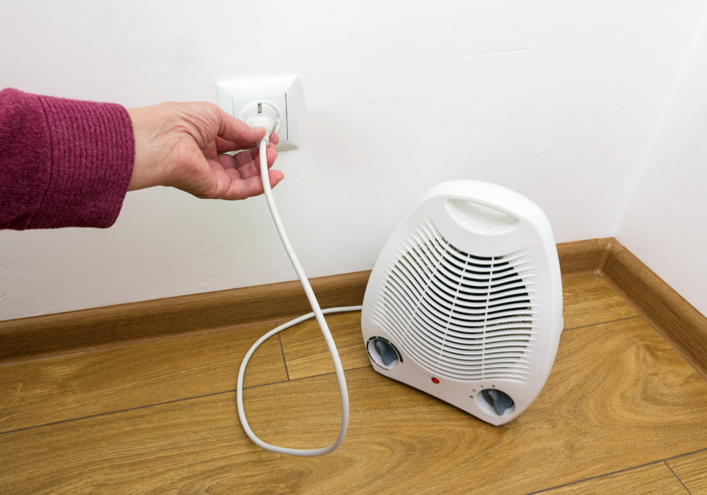 man plugging in space heater