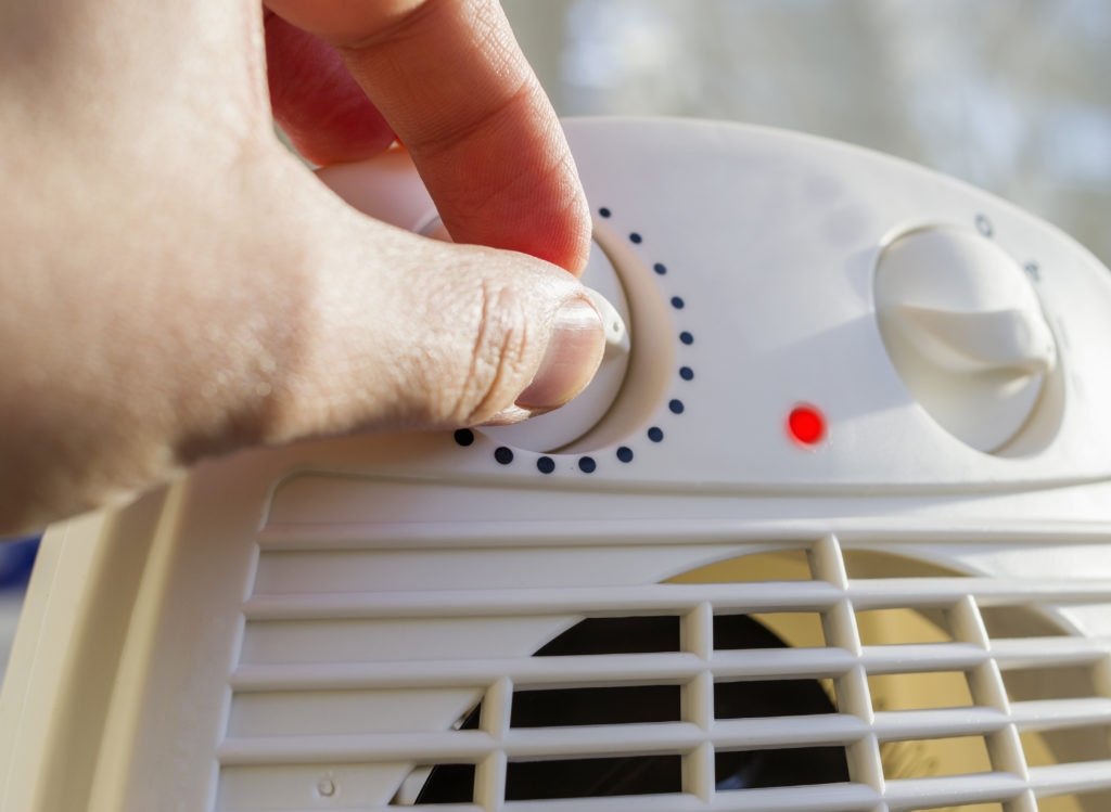 man turning on space heater